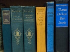 six Charles Dickens books in green, blue and yellow